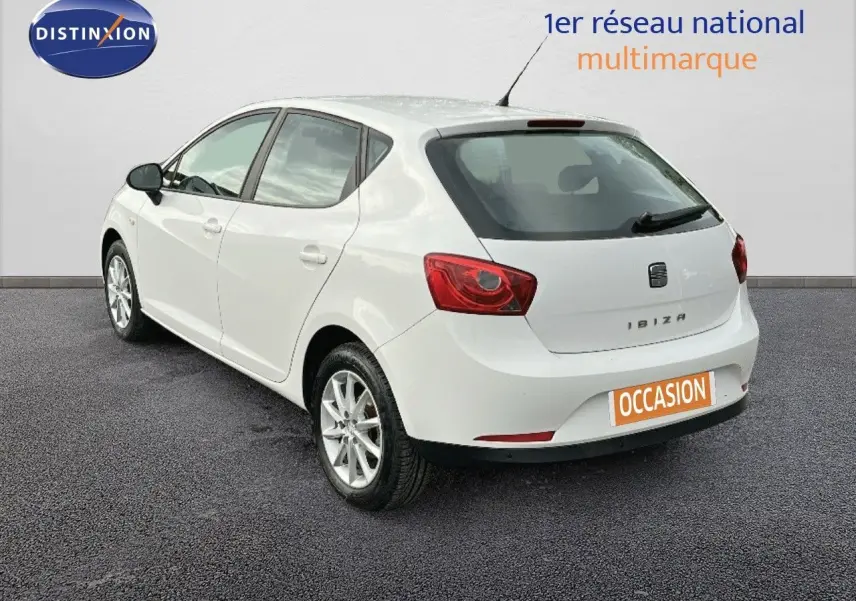 SEAT IBIZA blanche vue en 3/4 arrière côté gauche, avec feux arrière rouges et plaque "OCCASION" visible.