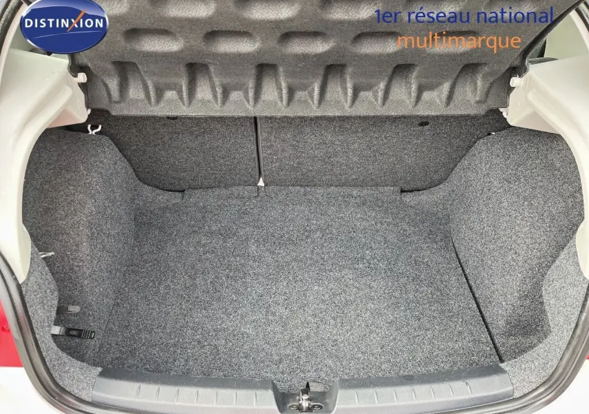 Coffre ouvert d'une SEAT Ibiza blanche 2010, vue arrière montrant l'espace de rangement vide et propre.