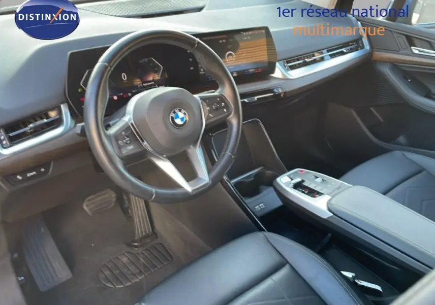 Vue intérieure côté conducteur de la BMW Série 2 Active Tourer 218i 2022, avec tableau de bord numérique et cuir noir.