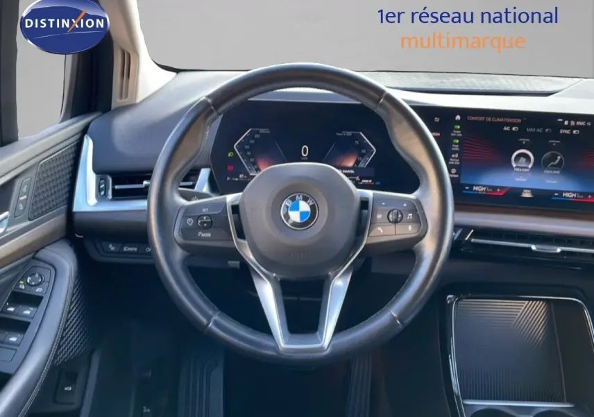 Vue intérieure centrée sur le volant cuir noir et le tableau de bord numérique de la BMW Série 2 Active Tourer 218i.