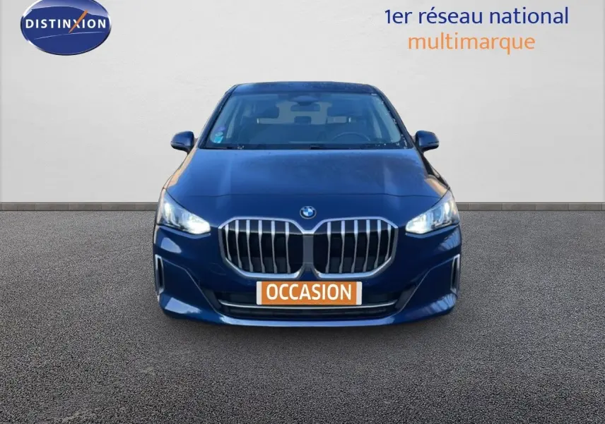 Vue frontale d'une BMW Série 2 Active Tourer 218i bleu phytonique métallisé avec calandre imposante et phares allumés.