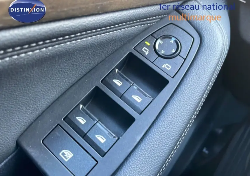 Gros plan sur les commandes de lève-vitres et rétroviseurs côté gauche en cuir noir de la BMW Série 2 Active Tourer bleu Phytonique.