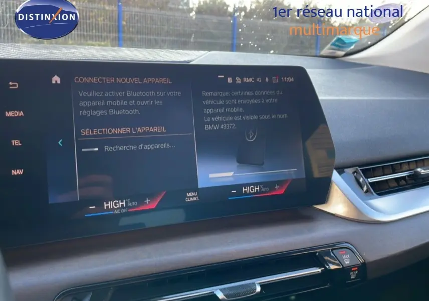 Écran tactile central du tableau de bord de la BMW Série 2 Active Tourer 218i 2022, affichant les réglages Bluetooth et climatisation.