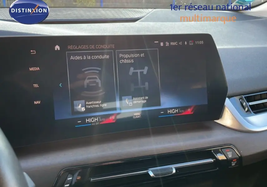 Vue intérieure du tableau de bord de la BMW Série 2 Active Tourer bleu phytonique, écran tactile affichant les aides à la conduite.