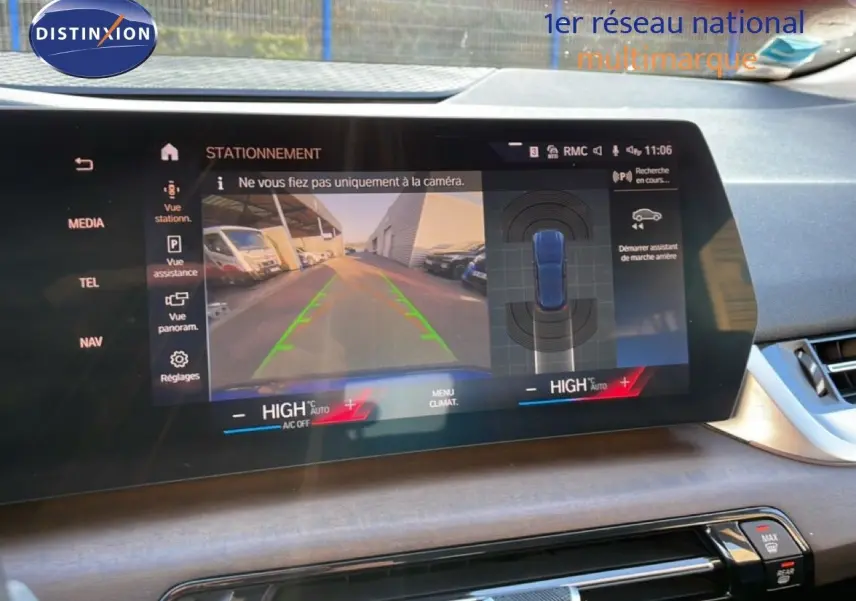 Écran central de BMW Série 2 Active Tourer 218i bleu phytonique, affichant la caméra de recul et l'assistance au stationnement.