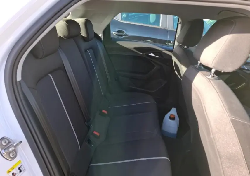 Gros plan sur la commande de lève-vitre côté gauche d’une Audi A1 blanche, intérieur noir texturé.