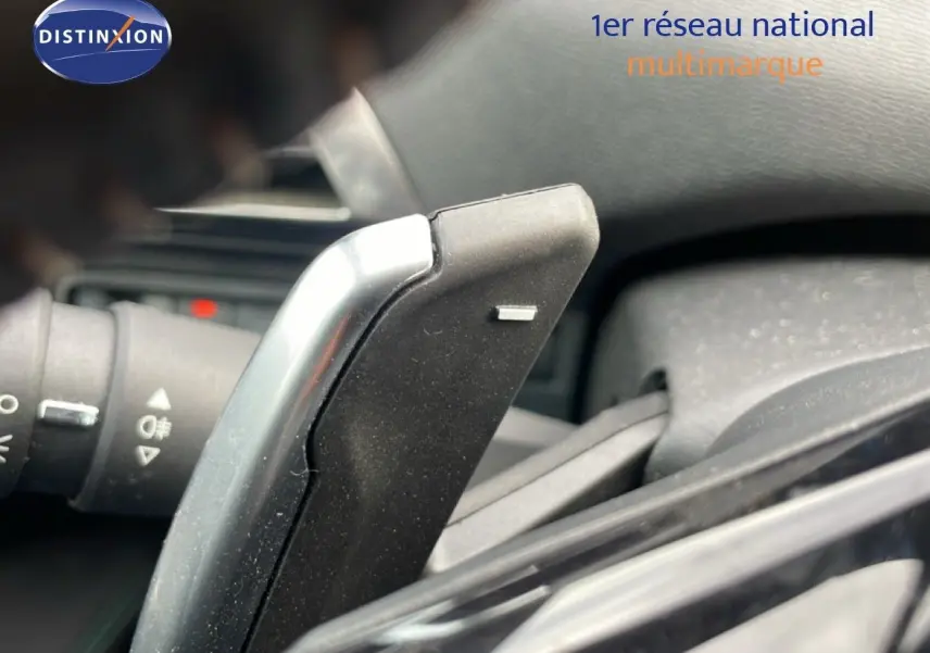 Gros plan sur la palette de changement de vitesse noire et argentée dans l'habitacle du Peugeot 3008 hybride.