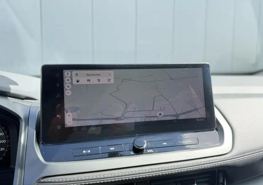 Écran tactile central affichant la navigation GPS dans l'habitacle du Nissan Qashqai blanc nacré 2025.
