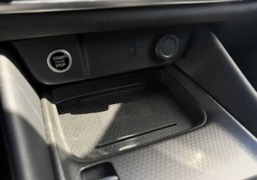 Gros plan sur la console centrale noire du Nissan Qashqai 2025, avec bouton Start/Stop et chargeur à induction.
