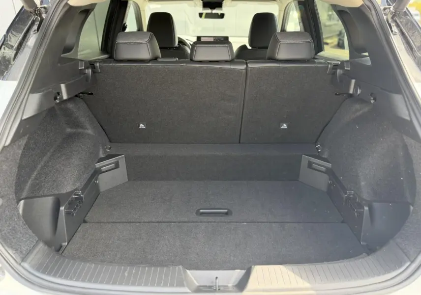 Coffre spacieux du Nissan Qashqai blanc nacré vu de l'arrière avec banquette arrière noire et plancher modulable.