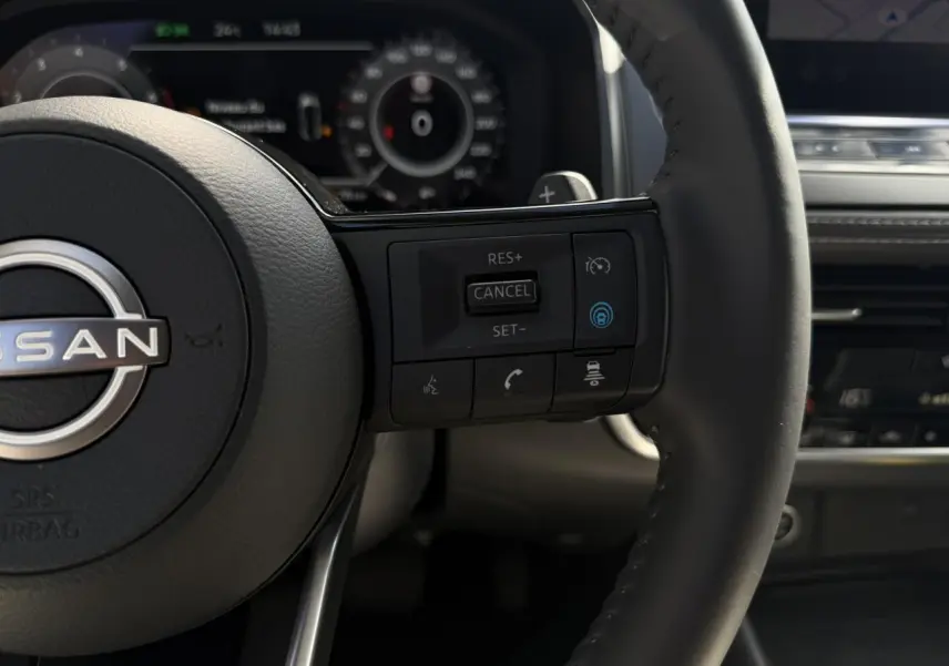 Gros plan sur le volant cuir noir du Nissan Qashqai 2025 avec commandes de régulateur et assistance au pilotage.