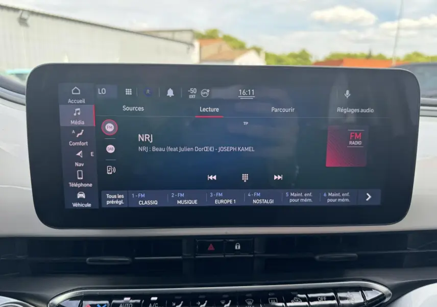 Écran tactile central de la Fiat 500 électrique 2022 affichant la radio NRJ avec commandes multimédia et climatisation en dessous.