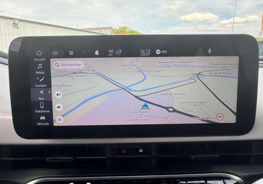 Écran tactile du système de navigation Uconnect 10,25" dans le tableau de bord d'une Fiat 500 électrique blanche.