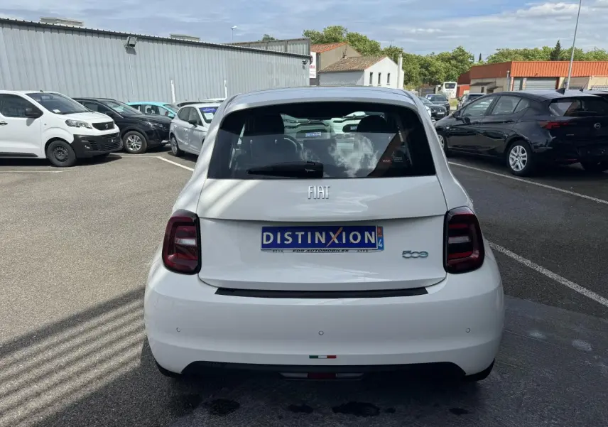 Vue arrière d'une Fiat 500 électrique blanche 2022 avec feux arrière foncés et logo FIAT visible.
