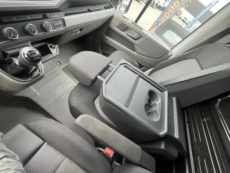 Intérieur du Volkswagen Crafter L3H3 Business Line 2019, vue côté conducteur sur sièges noirs et levier de vitesses manuel.