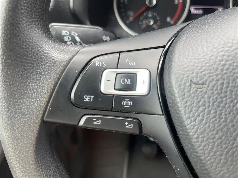 Gros plan sur les commandes de régulateur de vitesse au volant noir du Volkswagen Crafter Fourgon blanc 2019.