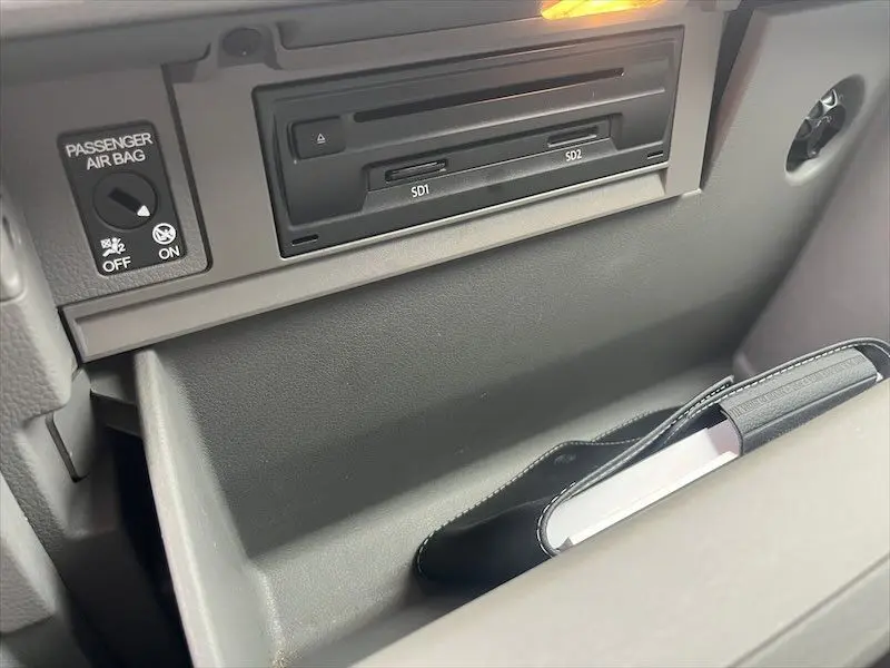 Détail de la boîte à gants grise avec lecteur SD et commande airbag passager du Volkswagen Crafter blanc 2019.