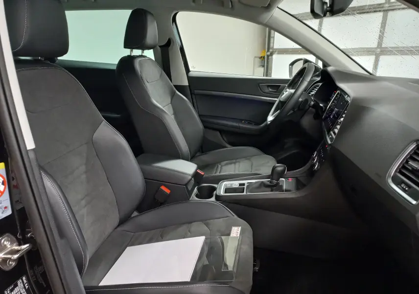 Vue intérieure côté conducteur du SEAT Ateca 2.0 TDI 150 DSG7 Copa, sièges noirs en cuir et alcantara, tableau de bord moderne.