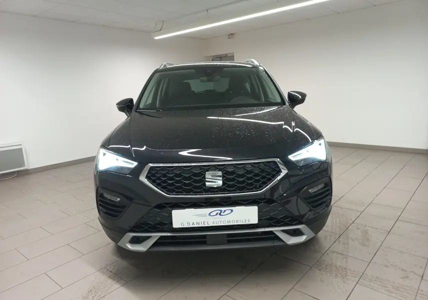 Vue frontale du SEAT Ateca 2.0 TDI 150 DSG7 Copa en Noir Magic Nacré avec phares allumés et calandre hexagonale.