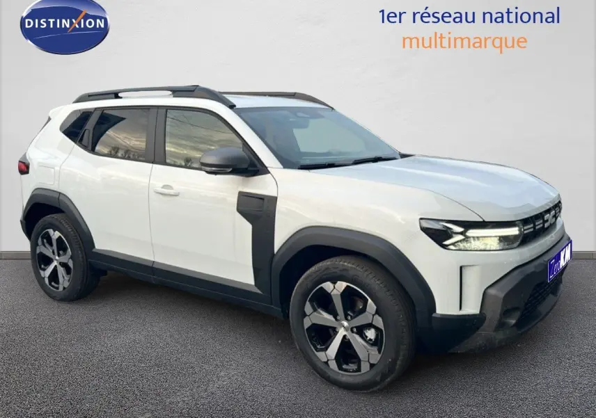 Vue 3/4 avant droit du Dacia Duster Hybrid 140 Journey blanc Glacier avec jantes alliage 18 pouces et barres de toit.