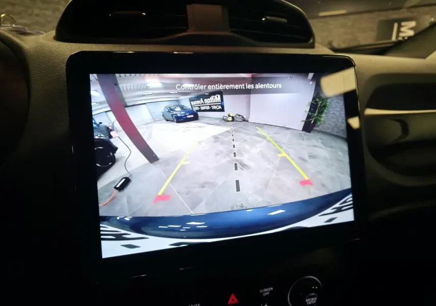Écran tactile intérieur montrant la caméra de recul du Jeep Renegade gris avec repères de stationnement en garage.