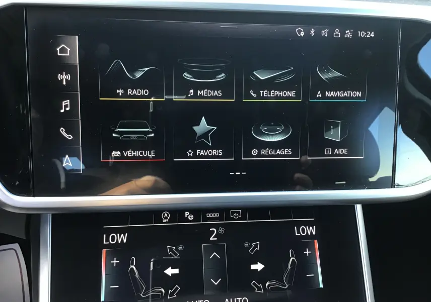 Écran tactile central de l'Audi A6 Avant 2022 blanc glacier, affichant le menu multimédia et les réglages climatiques.