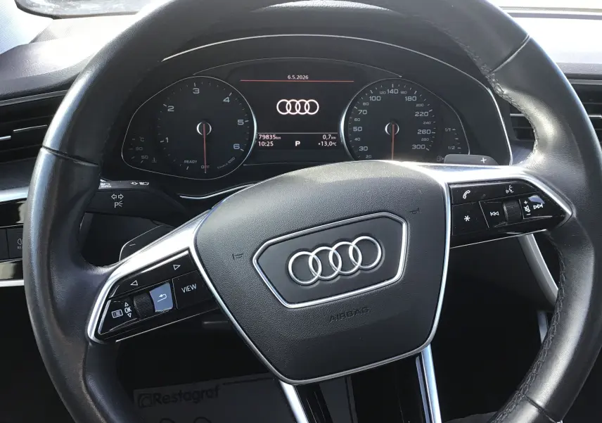 Vue rapprochée du volant cuir noir et du tableau de bord numérique de l'Audi A6 Avant 40 2.0 TDI blanc glacier.