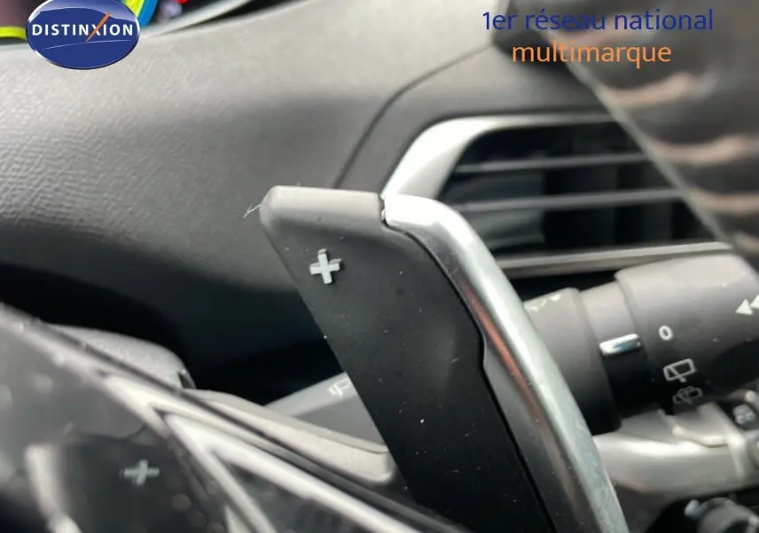 Gros plan sur la palette de changement de vitesse "+" du volant d'un Peugeot 3008 gris Artense hybride rechargeable 2024.