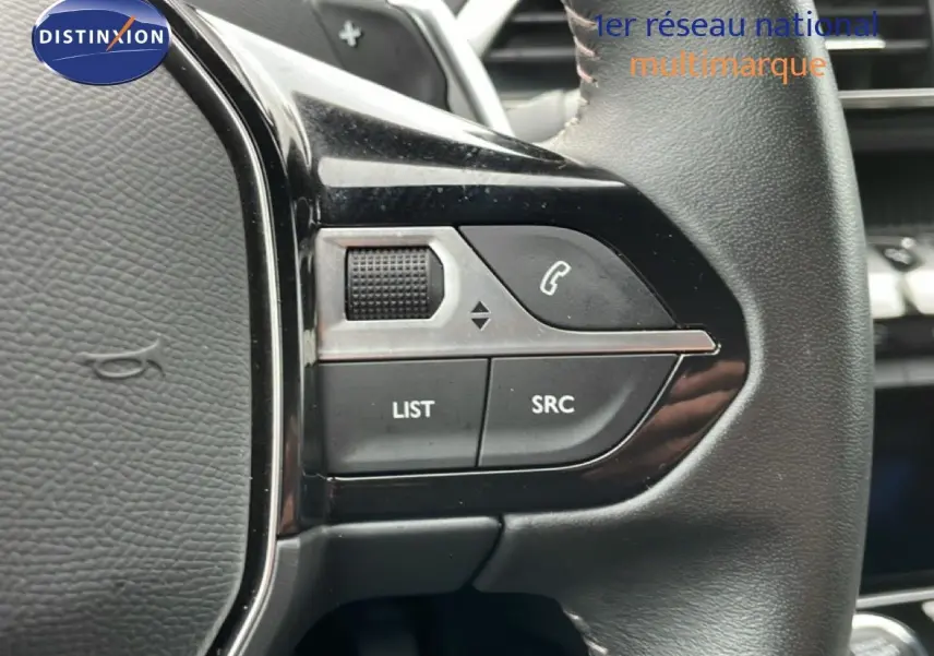 Gros plan sur les commandes gauche du volant en cuir noir du Peugeot 3008 gris Artense Metal 2024.