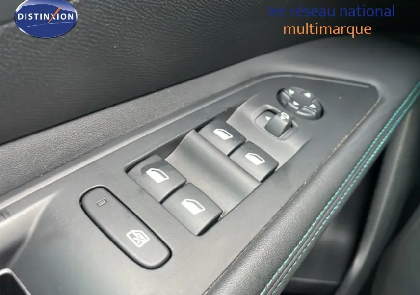 Gros plan sur les commandes des vitres électriques sur la porte côté gauche d’un Peugeot 3008 gris Artense Metal 2024.