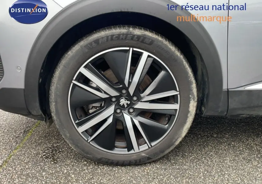 Gros plan sur la roue avant droite d’un Peugeot 3008 gris Artense Metal avec jante alliage bicolore.