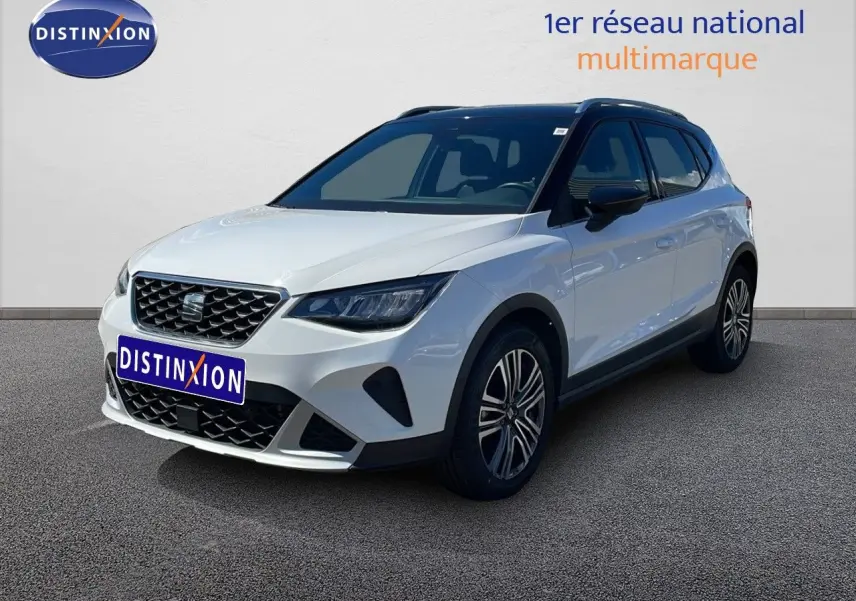 SEAT Arona blanc alpin métal avec toit noir, vue 3/4 avant droit mettant en valeur ses jantes alliage et calandre distinctive.