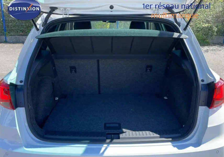 Coffre ouvert vu de l'arrière d'un SEAT Arona blanc alpin avec toit noir, montrant un espace de chargement vide et propre.