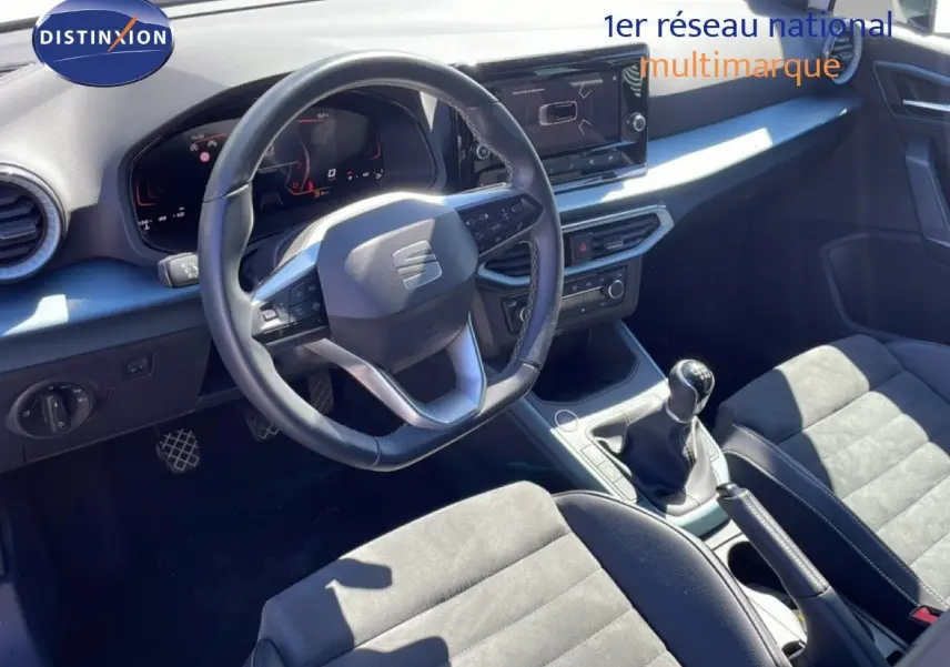 Vue intérieure côté conducteur du SEAT Arona 2025, volant cuir multifonction et tableau de bord numérique moderne.