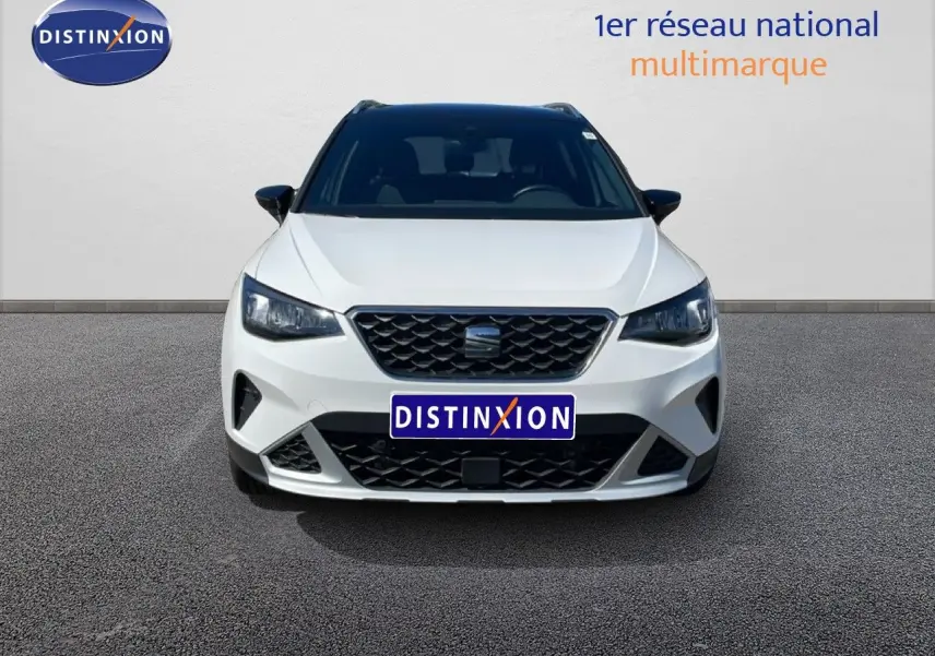 Vue avant d'une SEAT Arona blanc alpin avec toit noir, mettant en valeur sa calandre et ses phares LED.