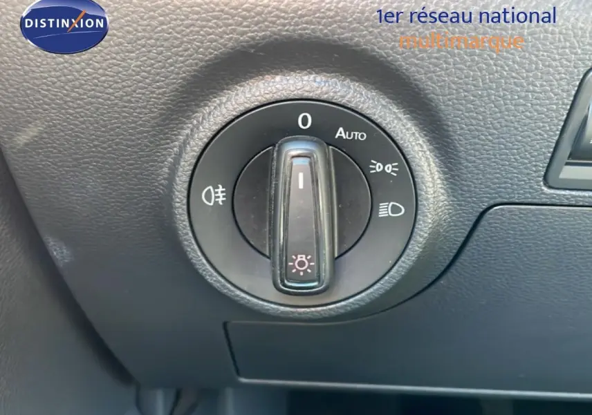 Gros plan sur le bouton de commande des phares du tableau de bord intérieur du SEAT Arona blanc alpin 2025.