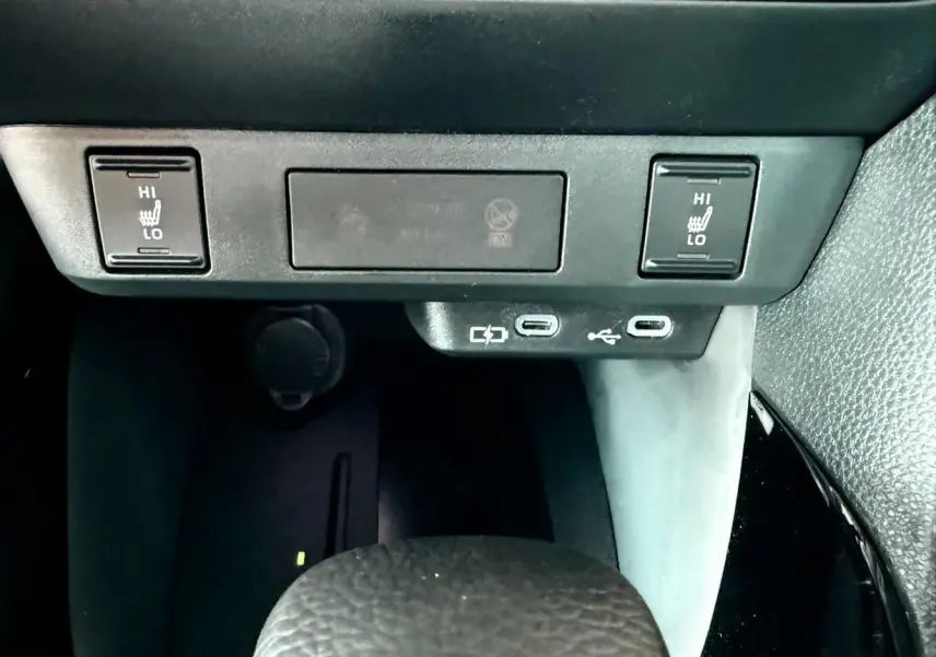 Détail de la console centrale de la Toyota Yaris Hybrid 2025 montrant les commandes de sièges chauffants et ports USB-C.