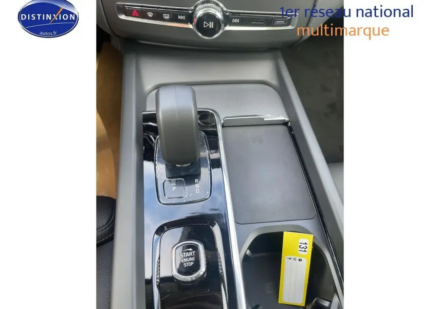 Gros plan sur la console centrale du Volvo XC60 gris 2024, avec levier de vitesse automatique et bouton start/stop.