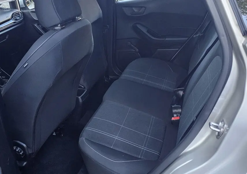 Vue intérieure arrière côté droit d'une Ford Fiesta 2021 gris lunaire, sièges tissu noir à motifs gris clair.