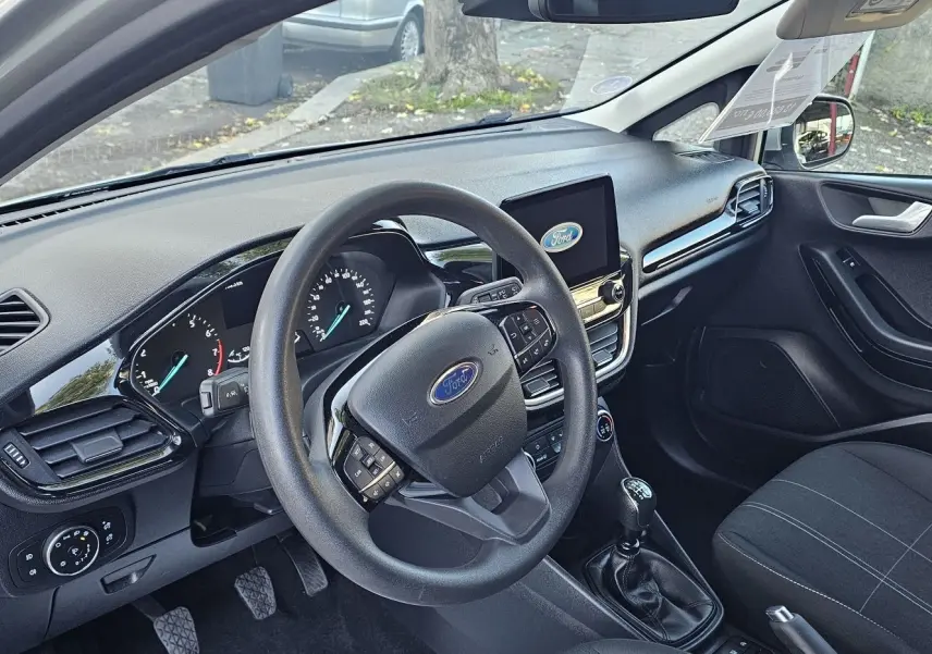 Intérieur avant gauche d'une Ford Fiesta 2021 gris lunaire, volant multifonction et tableau de bord avec écran tactile.