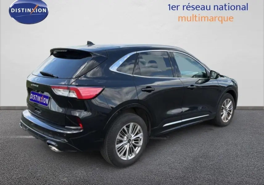 Vue 3/4 arrière droite d'un Ford Kuga noir 2024 avec jantes alliage et barres de toit visibles.