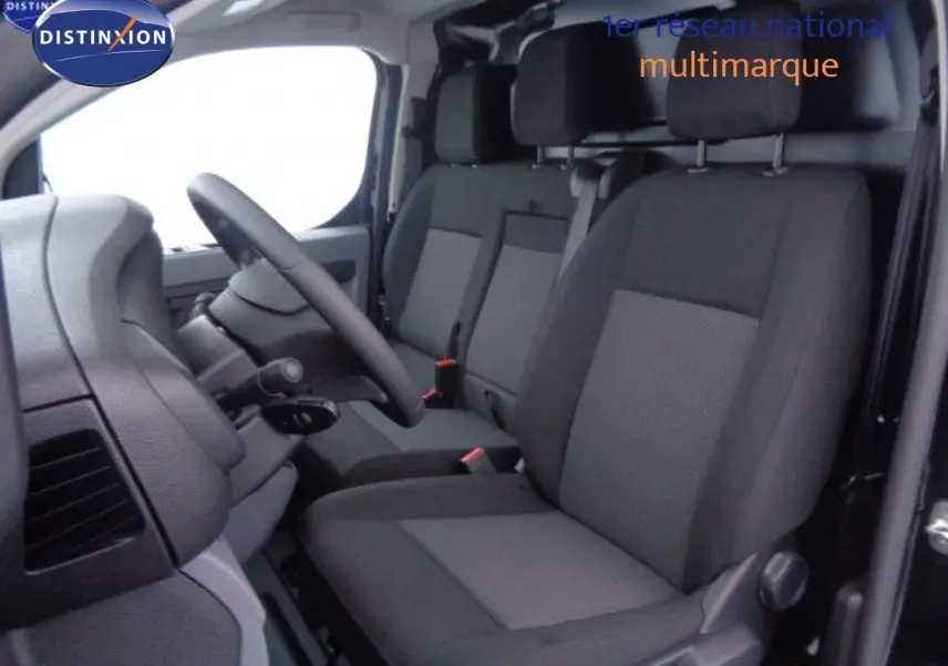 Intérieur du Peugeot Expert Fourgon 2022, vue côté conducteur sur les sièges tissu noir et gris, volant et tableau de bord visibles.