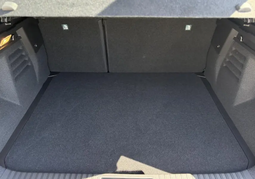 Coffre spacieux vu de face, intérieur gris foncé, sans chargement visible, Renault Symbioz 2025.