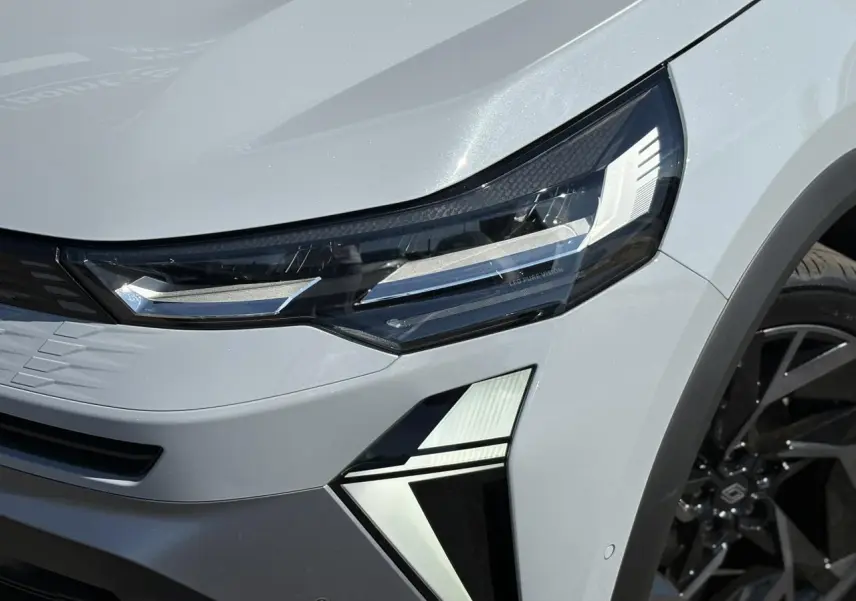 Gros plan sur le phare avant droit gris Rafale du Renault SYMBIOZ 2025 avec jante noire et détails LED distinctifs.