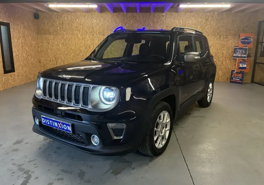 Jeep Renegade noir en 3/4 avant droit dans un garage, phare avant allumé et calandre distinctive à sept fentes.