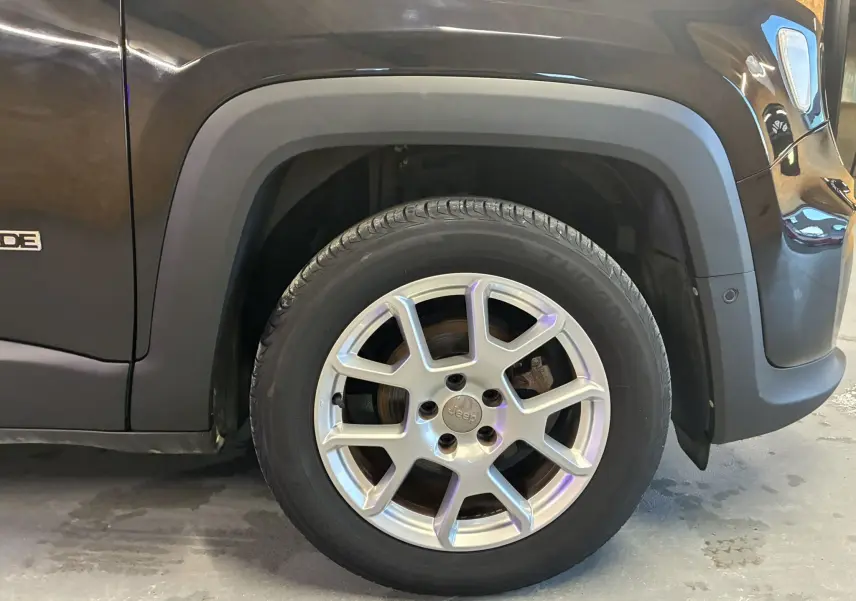 Gros plan sur la roue avant gauche du Jeep Renegade noir, mettant en valeur la jante en alliage et l'aile du véhicule.