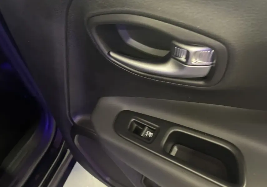 Poignée intérieure et commande de lève-vitre côté conducteur du Jeep Renegade noir, finition Limited 2019.