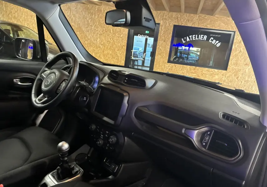 Intérieur noir du Jeep Renegade 2019, vue côté conducteur sur tableau de bord et volant avec boîte manuelle.