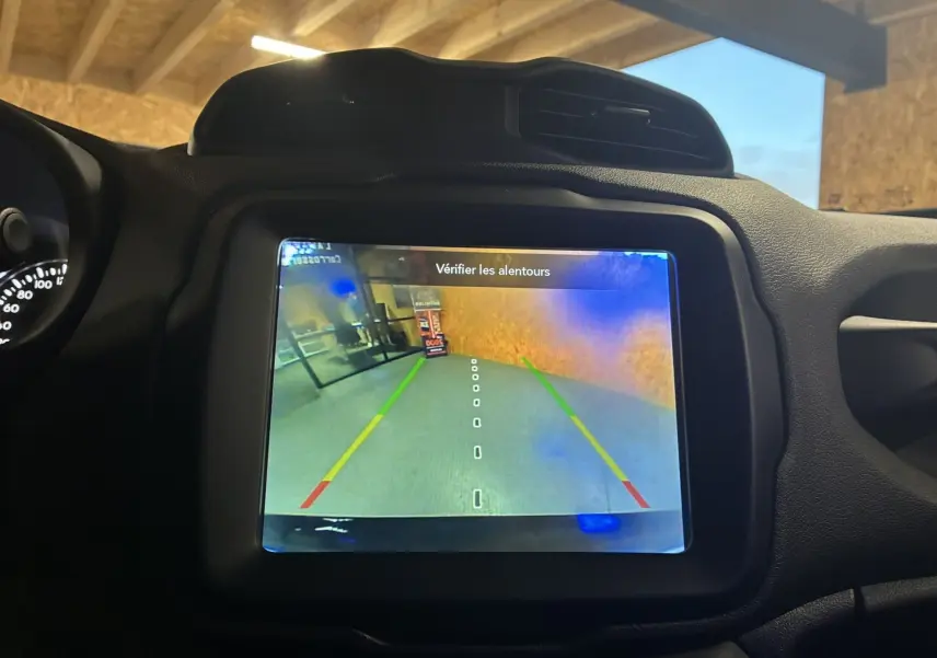 Écran de caméra de recul du Jeep Renegade noir 2019 affichant les lignes de guidage et un message de vigilance.