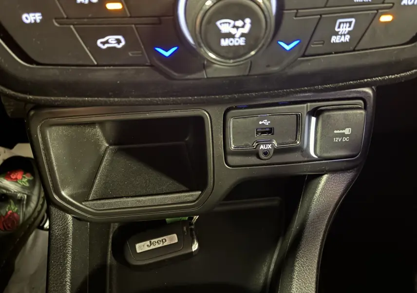 Gros plan sur la console centrale noire du Jeep Renegade 2019, montrant prises USB, AUX, prise 12V et clé Jeep.